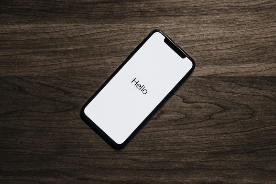 A smartphone displaying 'Hello' on a wooden surface, showcasing modern technology.